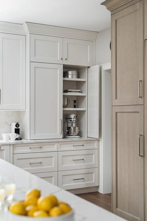 A stand mixer and baking trays are hidden in a dedicated area behind white cabinet doors and over white cabinets finished with a marble countertop. Kitchen Appliance Storage Ideas, Appliance Storage Ideas, Appliance Storage, 2022 Kitchen, Taupe Kitchen, Kitchen Appliance Storage, Appliance Cabinet, Built In Pantry, Corner Kitchen