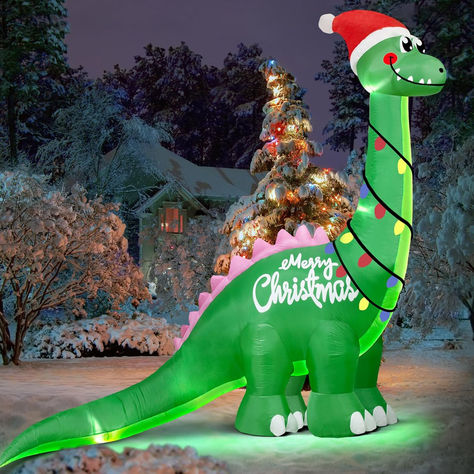 This large inflatable Christmas dinosaur decor, standing at an impressive 10 Feet when fully inflated, appears like an ancient behemoth emerging from the forest, leaving a lasting impression. This whimsical green dinosaur will transform your yard into the most attractive holiday display. Blow Up Dinosaur, Outdoor Xmas Decor, Christmas Yard Inflatables, Dinosaur Decorations, Christmas Blow Up, Xmas Decorations Outdoor, Inflatable Dinosaur, Christmas Dinosaur, Frugal Christmas