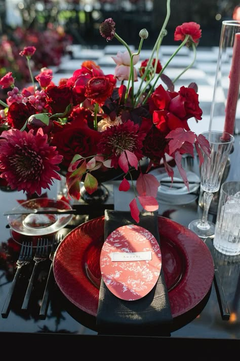 A place setting for an elegant wedding featuring a black table, linen and flatware along with a red menu, charger plate and low centerpiece for a fall reception. Wedding Color Schemes With Red, Color Schemes With Red, Red Table Settings, Best Color Combos, Fall Ambiance, Fall Reception, Black Centerpieces, Red Wedding Gowns, Red Centerpieces