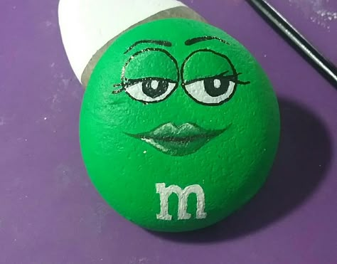 Green M&M painted rock- kindness rocks project M M Rocks, M&m Painting, M And M Painted Rocks, M And M Rock, M&m Rock Painting Ideas, M M Painted Rocks, M M Rock Painting, Rock Painting M&m, M&m Rocks Painted Stones