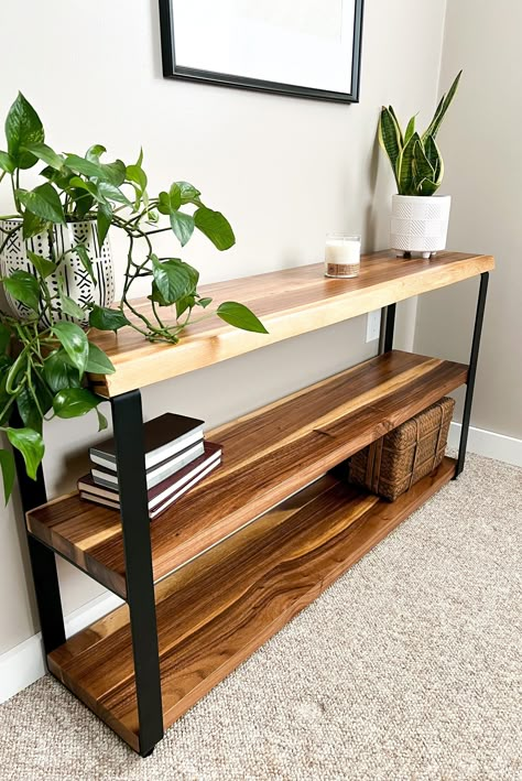 This stunning live edge bookcase combines the natural beauty of solid wood with the sleek, modern look of metal. The bookcase features a beautifully grained, live edge slab of wood that has been carefully selected and crafted to showcase its unique characteristics and natural imperfections. The rich colors and textures of the wood create a warm and inviting atmosphere, while the live edge design adds an organic touch that brings the outdoors inside. To contrast the natural beauty of the wood, the bookcase is supported by a set of sturdy metal legs. The legs have a minimalist design that perfectly complements the simplicity and elegance of the live edge slab. The metal legs are carefully welded and finished to ensure long-lasting durability and stability, making this bookcase a practical an Shelf Hallway, Live Edge Console, Rustic Mid Century Modern, Rustic Mid Century, Industrial Decor Living Room, Console Table With Shelf, Live Edge Console Table, Mid Century Modern Farmhouse, Live Edge Design