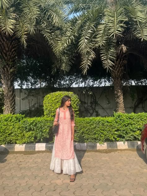 A girl wearing pink chicken kurti with white sharara standing in the sun. Chicken Sharara Suit, Pink Chicken Kurti, Pink Kurti Aesthetic, Pink Kurti Outfit Aesthetic, Chicken Clothes Kurti, White Plazo With Kurti, Short Kurti With Skirt, White Kurti Outfit, Chicken Kurti Designs