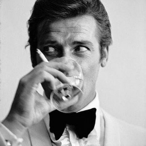 Long Island Film Society on Instagram: “Remembering #RogerMoore, gone 1 year today 🚬🥃 #bond #007 #cocktail #gq #smoking” Roger Moore 007, Shaken Not Stirred, Rudolf Nureyev, Roger Moore, Slim Aarons, Humphrey Bogart, Bond Films, Barbra Streisand, Vogue Covers