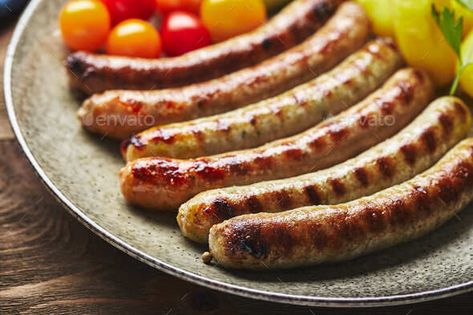 Tasty grilled sausages with potato and vegetables by Irrin. asty grilled sausages with potato and vegetables on plate in a close up view on wooden background. Top view, flat lay #Sponsored #vegetables, #Irrin, #asty, #potato Sausage Graphic Design, Sausage Photography, Grill Photography, Roasted Peppers And Onions, Grill Sausage, Pork Sausages, Grilled Sausage, Dried Basil, Chicken Steak