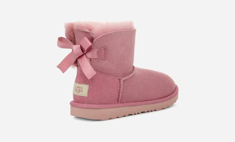 We added sweet, silky bows to your little one's favorite boot but kept the super-soft sheepskin feel they love. Built to move the way kids do, each boot features a rocker-bottom shape for a barefoot feel and our super-lightweight outsole for traction and durability. Pair with the same style in our women's sizes for cute mini-me moments. Pair with the same style in our women's sizes for cute mini-me moments.This product was made in a factory that supports women in our supply chain with the help o Ugg Boots With Bows, Pink Ugg Boots, Ugg Store, Kids Ugg Boots, Mini Baileys, Ugg Mini, Bailey Bow, Toddler Boots, Kids Uggs