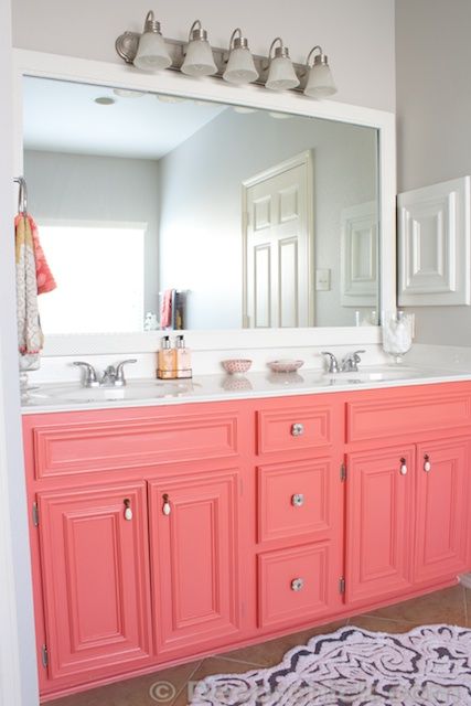 Gorgeous coral color painted bathroom vanity cabinet. Love the pop of color against the neutral grey walls. Inspiring DIY makeover from Decorchick. Coral Bathroom Decor, Shelves Styling, Coral Bathroom, White Counters, Bad Inspiration, Girls Bathroom, Cabinet Colors, Counter Tops, Ideas Bathroom