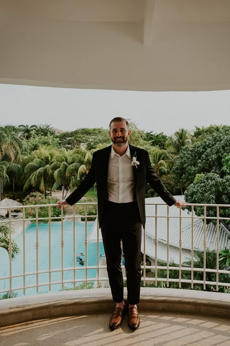 Handsome groom in all black suit and white button down without a tie looks sleek #groom #groomstyle #groomportrait #blacktie #blacksuit #groomfashion #destinationwedding #tropicalwedding #beachwedding #beachweddingstyle #groomweddingportrait #groompose #poseideas #costaricawedding #mexicowedding #hawaiiwedding #weddingphoto Destination Groom Attire, Black Suit No Tie Wedding, Black Suit No Tie, Costa Rica Beach Wedding, Linen Wedding Suit, Beach Groom, Groom Attire Black, Beach Wedding Black, Groom Suit Black