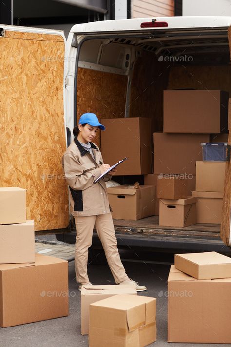 Woman making cargo delivery by AnnaStills. Young woman in uniform filling the form and checking packages before delivering she standing outdoors #Sponsored #AnnaStills, #Young, #woman, #delivery Delivery Uniform, Romans 8 37, New Flyer, Art Tutorial, Young Woman, Graphic Art, Quick Saves, Art