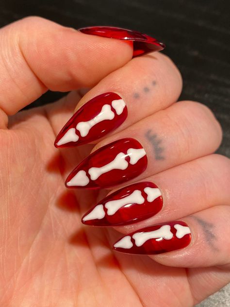 Hand painted press on nails with white bones over a sheer red jelly base. Shape pictured: STILETTO SHORT PLEASE READ: Use the nail sizing chart instructions from the photos to measure your nails. Then choose from the nail size options XS, S, M, or L. If your nails do not fit the standard sizes and you need custom sizing, please choose "CUSTOM" sizing and type in your custom sizes from thumb to pinky (ie. 1, 2, 3, 4, 5) under the "personalization" option. Please choose your length and shape. You Nail Art Designs Goth, Masculine Acrylic Nails, Lydia Deetz Nails, 80s Rock Nails, Red Pattern Nails, Horror Nail Designs, Red Halloween Nails Design, Red 2000s Nails, Red And Black Halloween Nail Designs