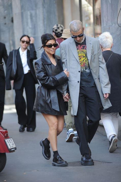 KOURTNEY Kardashian gave fans a sneak peek at her Met style as she walked hand-in-hand through Milan with fiance Travis Barker. The model and reality star looked like she wasn’t wearing any pants, as she toured the Italian city. Kourtney, 43 wore an extended black leatherish jacket – complete with matching tie belt. Travis, 46, went […] Kourtney Kardashion, Black Couple Outfits, 90s Girl Fashion, Kourtney Kardashian And Travis, Rock Star Outfit, Kourtney Kardashian Style, Italian City, Kardashian Outfit, Travis Barker