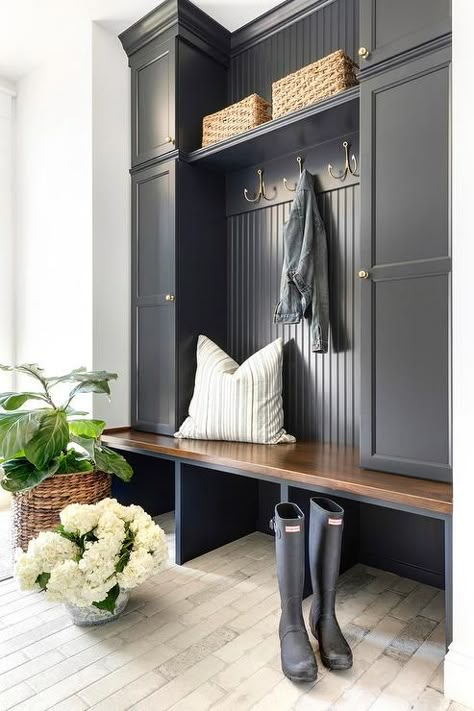 Charming black cottage style mudroom boasts light brick pavers contrasted with a black built-in bench topped with a stained wood seat fixed beneath stacked black locker cabinets adorned with antique brass knobs. Cottage Style Mudroom, Entryway Storage Ideas, Mudroom Cabinets, Mud Room Entry, Mudroom Decor, Mudroom Entryway, Home Entryway, Mudroom Laundry Room, Mud Room Storage