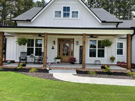 White Farmhouse Exterior, Rustic Barndominium, Ranch House Exterior, Small Barndominium, Porch Remodel, Black Roof, House Front Porch, Bedroom Barndominium, Farmhouse Landscaping