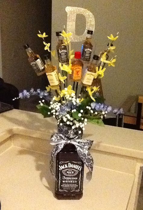 Made for my besties bday! Jack Daniels Whisky bouquet, using an extra large JD bottle on the bottom, taping a foam block on back and sticking mini Whisky bottle "flowers" all throughout, and adding in some real looking flowers as well! Jack Daniels Basket Ideas, Mini Alcohol Bouquet, Mini Bottle Bouquet, Booze Bouquet, Alcohol Bouquet, Bottle Bouquet, Alcohol Gift Baskets, Liquor Gift Baskets, Liquor Bouquet