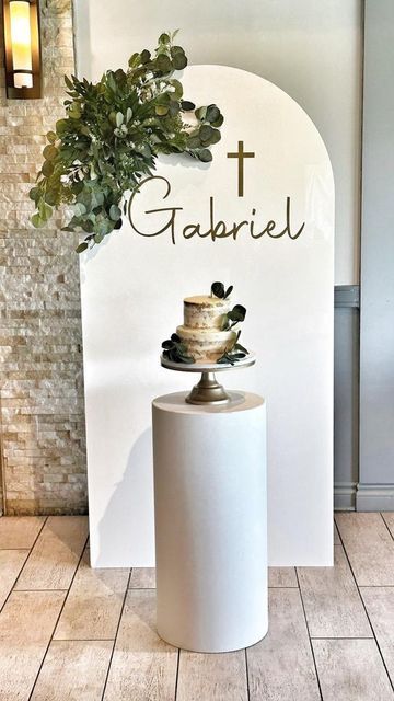 Rustique on Instagram: "God Bless Gabriel on his First Holy Communion 🙏 Our clients vision was to have their decor simple and fresh, perfect for a spring time celebration. We added a mixed greenery arrangement to our white acrylic arch backdrop. Gold personalization was added. A single plinth with a gold cake stand displayed the cake, making it the perfect photo opp! To tie in the theme, we incorporated eucalyptus garland throughout the dessert table, and added eucalyptus greenery to our fros Eucalyptus Decor Ideas, Simple First Communion Decorations, 1st Holy Communion Decorations, Baptism Arch Decor, Backdrop Arch Ideas, Krizma Decor, First Comunion Decoracion Ideas, First Communion Boy Decorations, 1st Communion Backdrop Ideas