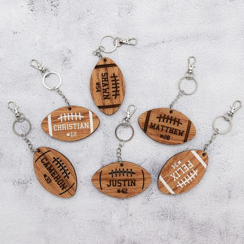 This wood keychain is a wonderful way to add personalization to your football player's bag. Whether it's their school bag or gear bag, let them represent themselves while looking stylish! Perfect for your football superstar! 3 football designs to choose from and you can get either a horizontal or vertical setup. Design A - all engraved Design B - Personalization is engraved and the design is laser cut Design C - engraved then painted white. The back has no design but is stained as well. Perfect School Bag Keychain, Football Bag Tags, Football Locker Decorations, Football Bags, Forge Projects, Football Team Gifts, Football Basket, Woman Costumes, Football Bag