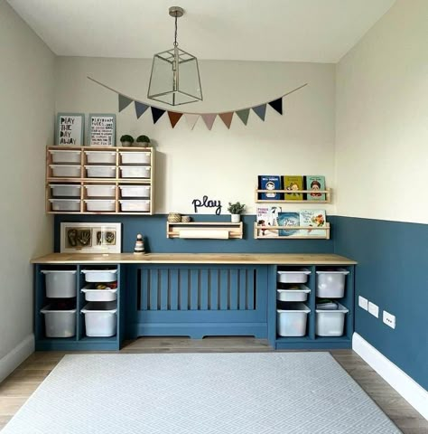 A gold lantern pendant light hangs over a light blue carpet on a hardwood playroom floor. A colorful banner hangs on a wall that is painted white and blue. Light wood wall storage units, bookshelves, and white bins are used to store and organize the books and toys...   Image: insidenumberseventy6 Dresser In Playroom, Rh Playroom, Painted Trofast Storage, Navy Blue Playroom, Painted Trofast, Boys Playroom Ideas Older, Lego Storage Ideas Ikea, Boys Bedroom Storage Ideas, Boys Room Ikea