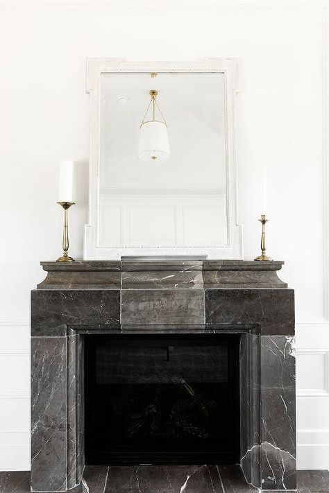 A white Greek key mirror sits on a French black marble fireplace mantel. Contemporary Fireplace Mantels, Statement Fireplace, W Design Collective, Sunrise Drive, Fireplace Styling, Fireplace Black, Marble Fireplace Mantel, Brick Fireplace Makeover, Small Fireplace