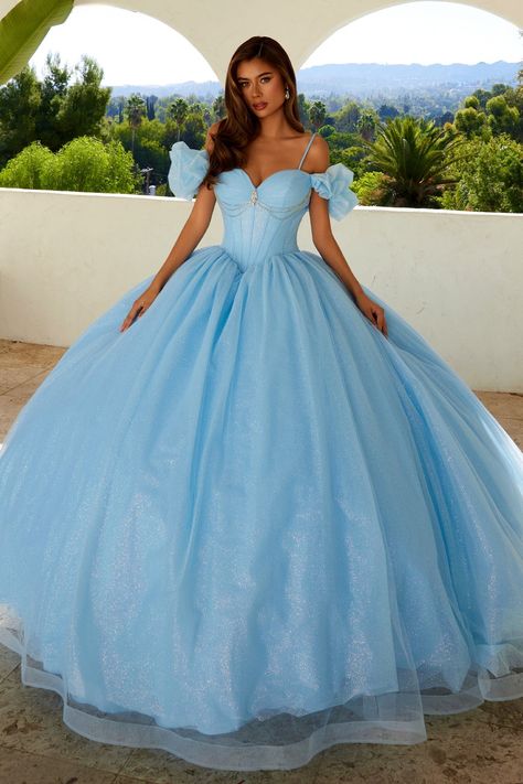 Sparkle and shine in this glitter tulle long off the shoulder dress with an A-line skirt by Juliet JT1487H. This beautiful quinceañera dress exudes a princess-like charm, perfect for making a grand entrance. The gown features a fitted bodice with a sweetheart neckline, adding a touch of romance and elegance. The bodice is adorned with intricate sparkling embellishments, creating a dazzling effect that catches the light beautifully. Below the bust, there are delicate jewels hanging, adding an extra layer of sophistication and sparkle to the dress. Off-the-shoulder sleeves made of sheer fabric add an ethereal and delicate touch, enhancing the overall fairy-tale aesthetic. The full skirt extends into a wide, floor-length silhouette, crafted from layers of soft, flowing fabric that create a vo Princess Quinceanera Dress, Long Off The Shoulder Dress, Off Shoulder Ball Gown, Dama Dresses, Gown Skirt, Flowing Fabric, Dresses Quinceanera, Tulle Ball Gown, Ball Gown Skirt