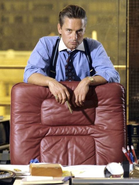 Michael Douglas in a scene from "Wall Street" pictured wearing a silk tie and elastic leather suspenders Wall Street 1987, Gordon Gekko, Michael Douglas, Jfk Jr, Kirk Douglas, George Clooney, Modern Gentleman, Frank Sinatra, New Wall