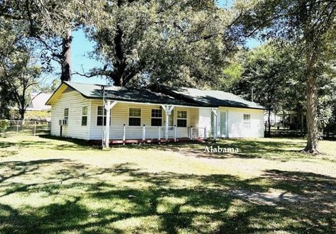 Cheap House in Alabama $85K The three bedroom, one bath ranch style home is a cheap house in Alabama with a broad front porch, large 0.57 acre lot and an outbuilding.   #cheaphouse Arched Front Door, Cheap House, Tudor Revival, Vinyl Exterior, Cheap Houses, Roll Up Doors, English Village, Cute Cottage, Ranch Style Home