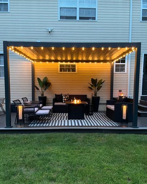 Donice (Dah-neece) on Instagram: "Home lately 🖤  It’s cozy, summer nights on the patio season 🖤  Louvered Pergola @miradoroutdoor  Indoor/outdoor rug @jonathany_official  String lights @jonathany_official   #patio #patioseason #pationights #patiolights #patiodesign #pergoladesign #louveredpergola #louveredroof #louveredpergolas #patiorugs #patiorug #blackpatio #blackpatiodecor #patiostringlights #pergolas #patioinspo #patioinspiration #patioliving #patiolife #modernpatio" Pergola Lights String Ideas, Corner Patio Ideas, Pergola Decorating Ideas, Cozy Backyard Ideas, Patio Lights String Ideas, Backyard Pergola Ideas, Patio Pergola Ideas, Patio Shade Ideas, Patio Roof Ideas