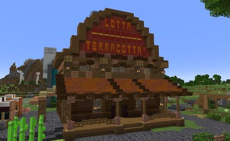 A Minecraft terracotta shop in the style of a Wild Western saloon. The build has a ground floor made of dark oak, with a spruce porch in front of it and an orange acacia roof. The second floor is comprised of spruce and jungle wood, and has a large round sign above it titled 'Lotta Terracotta'. Minecraft Terracotta, Minecraft Roof, Western Saloon, Cute Minecraft Houses, Minecraft Construction, Minecraft Inspo, Minecraft Mods, Minecraft Houses, Wood Shop