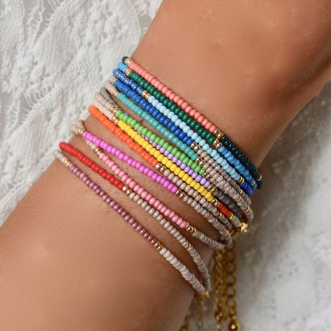 Set of three delicate colourful gold stacking bracelets in a rainbow of colours. Lots of colours from which to choose. Play around with our best-selling beaded stacking bracelets to create the perfect 'arm candy'. These bracelets are a great gift for all ages from Teenagers, Mums, Sisters and Friends. Bracelets have been created in a rainbow of colours and designs with 14kt gold plated glass and colourful Japanese Miyuki seed beads. Wear them stacked in a rainbow of colours for a statement 'effe Colourful Beads Bracelet, Teenage Bracelets, Friends Bracelets, Summer Necklaces, Colorful Bead Bracelets, Matching Jewellery, Beaded Necklace Designs, Stacking Bracelets, Beaded Necklace Diy