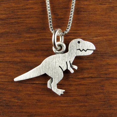 "This fierce little T-rex is made of sterling silver. The pendant is quite TINY, measuring just under 5/8\" tall (1.5 cm) and 7/8\" long (2.1 cm).  Super cute! You can purchase just the pendant/charm, or complete the necklace with a sterling silver box chain (four lengths are available). © Stick Man Creations This is our own original design, handcrafted by us, and signed on the back with our logo.   If you want to read more about the process, click here:  https://www.etsy.com/shop/StickManJewelr Tiny Dinosaur, Dinosaur Pendant, Flatware Jewelry, Dinosaur Necklace, Silver Casting, Man Jewelry, Stick Man, Whimsical Jewelry, T Rex Dinosaur