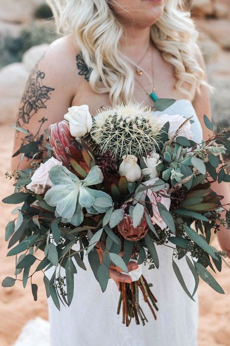 Watch were you point that thing! Surrounded by white roses, succulents and eucalyptus, a small barrel cactus makes for a unique centerpiece in this boho desert wedding bouquet. Cactus Bouquet Wedding, Southwestern Floral Arrangements, Cactus And Lace Weddings, Desert Wedding Bouquet, Cactus Bouquet, Desert Wedding Decor, Desert Weddings, Neutral Wedding Decor, Bilingual Wedding