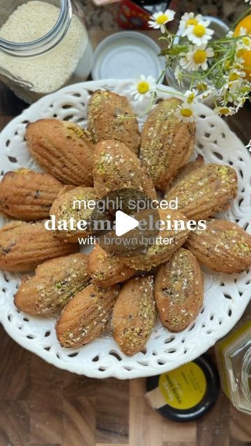 Yasmine Idriss Tannir on Instagram‎: "Date madeleines with meghli spices and brown butter. If you want a dessert inspired by happiness, that is it.  Meghli is a pudding made with rice flour, sugar and lots of spices. It is served when babies are born, customarily decorated with shredded coconut and nuts These moist little madeleines are packed with flavors reminiscent of happy occasions and births.  اللغة العربية بالأسفل! Makes 15  100 g unsalted butter, melted, plus more, softened, for brushing ½ cup (65 g) almond flour  3/4 cup plus 2 tbsp (135g) all-purpose flour 3/4 tsp baking powder  1/4 tsp fine salt, La Baleine  2 tbsp (25 g) brown sugar Finely grated zest of 1 orange  1tsp orange blossom  2 large eggs 1/4 cup (80 g) clover honey, SpinneysFOOD, extra to brush  1/4 tsp cardamom 1/4 t Rice Flour, Coconut Sugar, Shredded Coconut, Brown Butter, Unsalted Butter, Almond Flour, Purpose Flour, Baking Powder, Brown Sugar