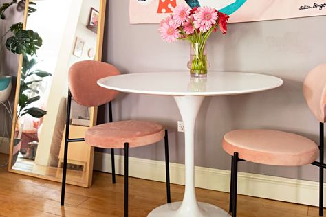 Dining nook with small white tulip table, 2 pink chairs with black legs wood floor, vase of pink and red flowers, full length mirror on floor Black Tulip Dining Table, Tulip Dining Table And Chairs, White Tulip Dining Table, Round Pedestal Dining Table And Chairs, Tulip Table Styling, Tulip Table Dining Room, Tulip Table Decor, Tulip Table And Chairs, Small White Dining Table