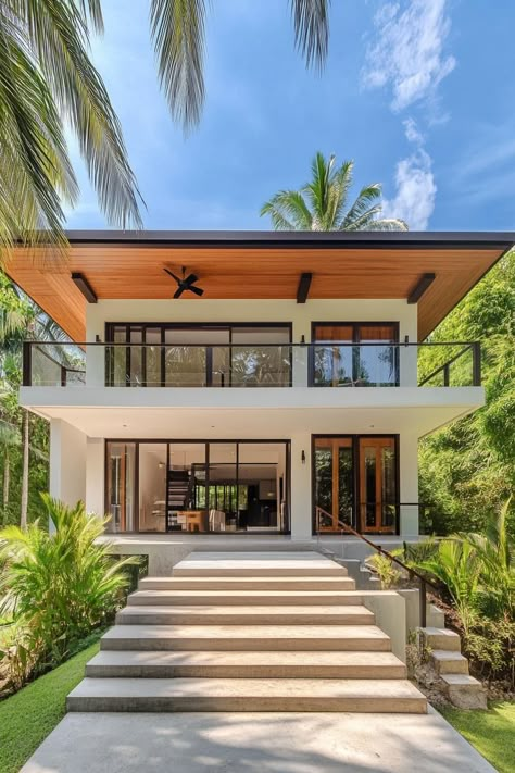 A sleek, modern house with tropical vibes surrounded by lush greenery. Here’s how tropical minimalist houses blend simplicity with vacation vibes, effortlessly creating that paradise-found feeling right at home. Tropical Open Space House, High Ceiling Tropical House, Tropical Guest House, House In The Tropics, Exterior House Photography, Modern Tropical Home Exterior, Modern Tropical House Floor Plan, Modern Minimalist Beach House, Tropical Home Design Architecture