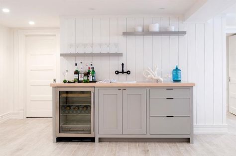 BASEMENT BAR - Amazing basement wet bar features a vertical shiplap wall lined with gray cabinets fitted with a glass door beverage fridge and an oval sink under a bronze wall mount sink as well as gray staggered floating shelves. Basement Family Rooms, Gray Basement, Wet Bar Basement, Basement Wet Bar, Basement Kitchenette, Decor Pad, Basement Kitchen, Basement Family Room, Small Basements