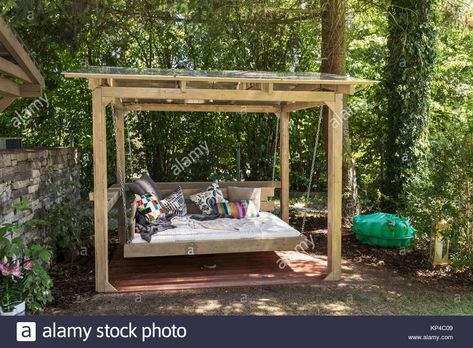 Download this stock image: Big swing outdoor bed. Chaise longue in the garden in the pergola. Garden bed with pillows. Big outdoor bed for sunbathing and rest. Four garden bed. - KP4C09 from Alamy's library of millions of high resolution stock photos, illustrations and vectors. Railway Sleeper Beds, Rock Bed, Earth Bag, Swing Bed, Pergola Swing, Backyard Gazebo, Pergola Garden, Outdoor Daybed, Lawn And Landscape