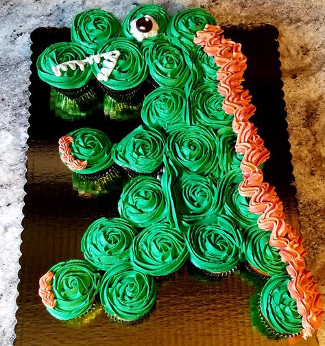 Dinosaur pull apart cupcake cake displayed on half sheet board. Gator Cake, Dinosaur Cupcake Cake, Pull Apart Cupcake, Dinosaur Cupcake, Dinosaur Birthday Theme, Swamp People, Pull Apart Cupcake Cake, Whiskey Cake, Pull Apart Cake