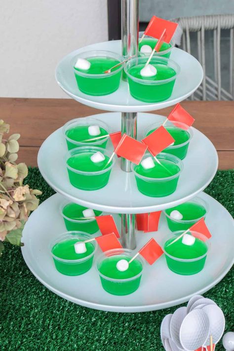 Green golf Jello shots for a gold party. Golf Jello Shots Recipe, Golf Themed Jello Shots, Masters Party Food Ideas, Golf Themed Appetizers, Golf Jello Shots, Golf Party Ideas For Men, Golf Themed Food Party Ideas, Golf Dessert Ideas, 50th Birthday Golf Theme