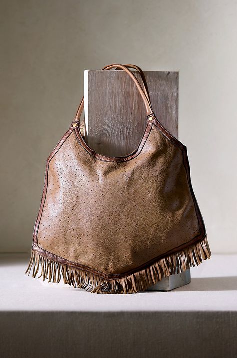 Designed for versatility, the fringed Taos leather bag easily transforms into a high crossbody style, making it ready to go everywhere. This casually chic bag features a stylish slouch profile that only looks better with use, thanks to its soft, washed leather and subtle floral laser print. With numerous secure pockets inside, the lightweight Taos is versatile for everyday use. It also packs easily in luggage for a bohemian accessory while traveling. Business Travel Bag, Casually Chic, Italian Leather Bags, Sheepskin Slippers, Suede Handbags, Bohemian Accessories, Western Hats, Chic Bags, Taos