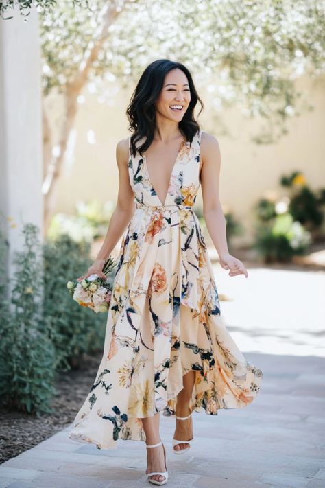 Smiling woman in a floral dress walking outdoors. Wedding Abroad Dresses Guest, Formal Dresses Summer Wedding, Aline Wedding Guest Dress, Safari Wedding Guest Outfit, Beach Formal Attire Women Wedding, Puerto Vallarta Wedding Guest Outfit, Napa Valley Wedding Guest Dress, What To Wear To A Garden Wedding, Wedding Guest Italy Outfit