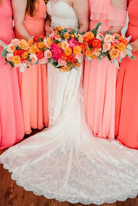 Don't fear color when it comes to wedding fashion and flowers. These coral and pink mismatched bridesmaids dresses added personality to the celebration and matched the stunning pink and orange bouquets perfectly. This is a stunning color palette for those spring or summer weddings. | John Myers Photography & Videography Pink Coral Bridesmaid Dresses, Bridesmaid Dresses Not Matching, Red Orange Purple Pink Wedding, Pink And Orange Wedding Theme Groomsmen, Red And Coral Wedding, Orange And Pink Wedding Flowers, Red Pink Orange Wedding, Sunset Wedding Flowers, Orange And Pink Bridesmaid Dresses