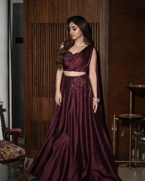 A sight to behold: @saieshagogia10 in our draped wine lehenga set. DM us for outfit details. Umbrella Lehenga Designs, Wine Lehenga Party Wear, Satin Lehanga Designs, Wine Colour Outfits, Wine Colour Dress Indian, Reception Indian Outfit Guest, Lehenga Ideas For Brother's Wedding, Burgundy Lehenga Simple, Wine Gown Dress