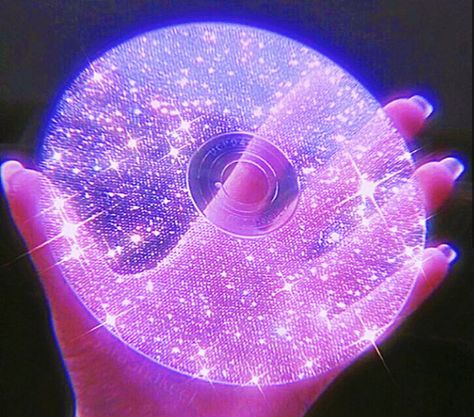 A hand with long nails holding a bright sparking purple CD that’s transparent and has glitter Purple Glow Aesthetic, Purple Spidersona, Bright Purple Aesthetic, Savannah Core, Shiny Aesthetic, Sparkle Aesthetic, Cd Aesthetic, New Retro Wave, Dark Purple Aesthetic