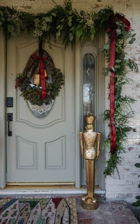 Sage green front door and a mix of cedar garland, Eucalyptus and baby’s breath. Front Door Christmas Arch, Christmas Outdoor Door Arch, Greenery Around Front Door Christmas, Porch Garland Christmas Decorating Ideas, Christmas Greenery Door, Front Door Garland Christmas, Garland Around Front Door, Christmas Garland Front Door, Front Door Christmas Garland