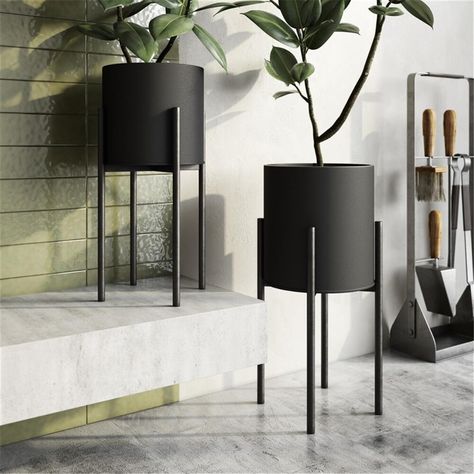 The sleek modern design of these planters let them complement any mid century modern or modern space but they will blend with boho or glam styles as well Raised on a set of high legs the planters neutral design will add great contrast to the green of any flowers plants or succulents Ideal for a foyer covered patio or living room you can use them for visual contrast against a neutral or colored wall Features . Jaxon Modern Planters. Matte black pots with a gold rim. Crafted from metal. Sleek mode Cream Living Room With Black Accessories, Black And Gold Accessories Living Room, Beige Living Room Black Accessories, Black Plant Stand Living Rooms, Modern Home Accessories Living Room, Neutral Living Room With Black Accessories, Center Piece For Living Room Table Modern, Tattoo Modern, Tattoo Plant