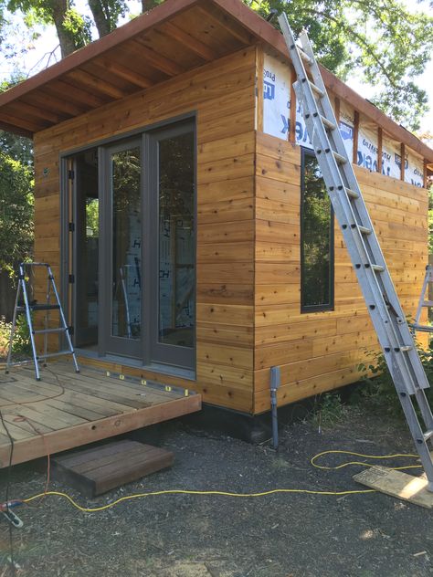 Adding the 1x8x8 T&G Cedar Siding-- Rain Screen  to the studio shed, the Cedar is treated with 1 coast of Cabot Aust. Timber Oil. Front 3 panel door is Andersen 8x0 Shed Architecture Design, 3 Panel Door, Rain Screen, Office Exterior, Farm Resort, Cedar Shed, Tiny Cottages, Shed With Porch, Shed Tiny House