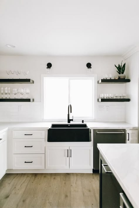 Forgo color for a classic palette of black and white. BLANCO’s Anthracite IKON farmhouse sink makes a stunning statement piece in this kitchen. | Farmhouse Decorating | Farmhouse Inspiration | Farmhouse Homes | Farmhouse Room | Farmhouse Kitchen | Farmhouse Interior | Farmhouse Faucet | Kitchen Faucets Farmhouse | Black and White Kitchen | White Cabinetry | White Cabinets | Matte Black Hardware | Open Shelving Ideas | Black Kitchen Faucet | Big Sink | Home Decor | Home | Interior Design Small Farmhouse Sink, Black Farmhouse Sink, White Farmhouse Sink, Black Kitchen Sink, Kitchen Sink Design, Black Sink, Kitchen Lights, Kitchen Interiors, Farmhouse Kitchen Design