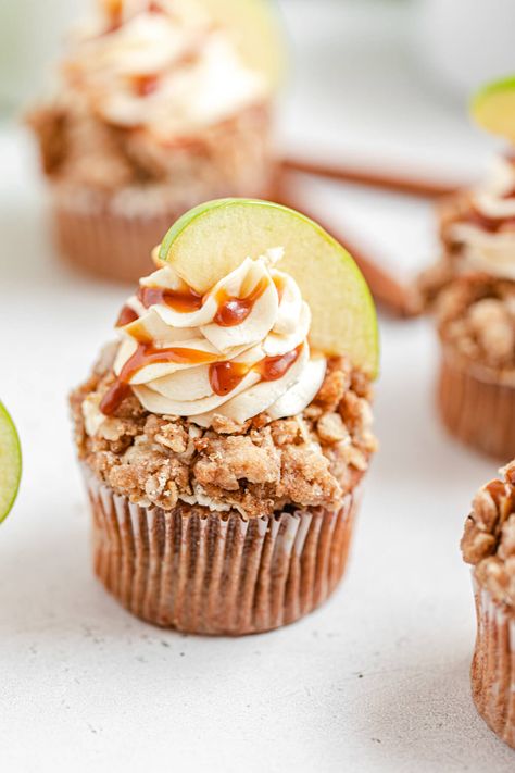 These Caramel Apple Crumble Cupcakes are made with a fluffy cinnamon cupcake with fresh apple pieces baked inside, a warm apple filling and a salted caramel cream cheese frosting dipped in a crunchy crumble topping for the ultimate Fall treat! | queensleeappetit.com Apple Crumble Cupcakes, Crumble Cupcakes, Cupcakes Cinnamon, Caramel Cream Cheese Frosting, Caramel Crumble, Caramel Apple Crumble, Caramel Apple Cupcakes, Cinnamon Cupcakes, Caramel Apple Crisp