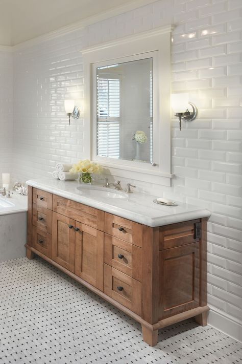 White-impact subway style tile work all through this bespoke bathroom makes the profound. #darkwoodcabinets #darkwoodcabinetry #darkwoodcupboard #oakwoodcabinets #whitequartz #quartzcountertops #quartztops #whitecountertops #subwaytiles #subwaybacksplash #subwaytile #whitesubway #whitebacksplash #whitetiles #mosasictiles #mosaicfloortiles #mosaicfloor #shakercabinets #vanitycabinets #bathroommirrors #whitesink #porcelainsink #whiteporcelainsink #bathroomideas #sink #blackhandles #whitebathrooms White Beveled Subway Tile, White Subway Tile Bathroom, Tile Selection, Metro White, White Quartz Countertops, White Tile Shower, Dark Wood Bathroom, Wood Bathroom Cabinets, Beveled Subway Tile