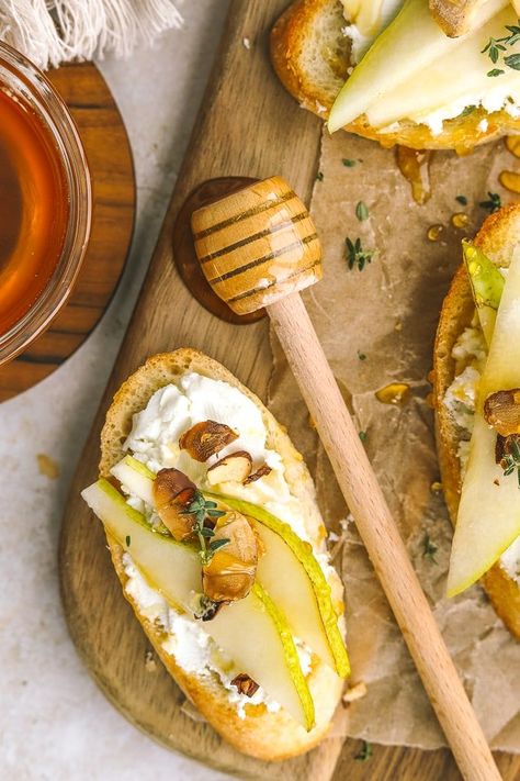 Make these pear appetizers in under 20 minutes! Crostini topped with goat cheese, sliced pear, toasted almonds & honey are the perfect bite for the holidays. Easy to make and delicious! Pear Goat Cheese Appetizer, Pear And Goat Cheese Crostini, Prosciutto Pear Appetizer, Brie Pear Crostini, Pear And Cheese, Bacon Wrapped Pears, Pear Crostini Appetizers, Pear Toast, Pear Bruschetta