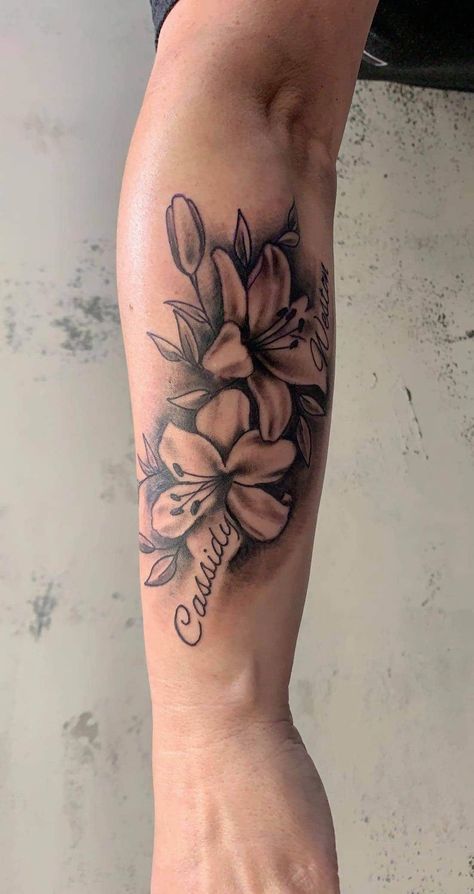 Lily Flower Name Tattoo, Tattoos With Names And Flowers, Flower Tattoo With Names In Petals, Floral Tattoo Design With Name, Flowers Around Name Tattoo, Front Torso Tattoos For Women, Flamingo Family Tattoo, Two Name Tattoos, Floral Tattoo With Names