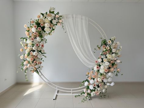 This stunning wedding arch is adorned with a beautiful array of wedding flowers, creating a breathtaking focal point for your special day. Featuring a mix of real-touch flowers and high-quality artificial flowers, this arch provides the perfect blend of elegance and realism. The wedding arch flowers include exquisite artificial roses, meticulously crafted to mimic the beauty of fresh blooms. These flowers are designed to create a lush, romantic atmosphere, making the arch a captivating centerpie Round Arch Flower Decoration, Artificial Flower Arch Wedding, Gold Circle Arbor Wedding, Wedding Round Arch Ideas, Shower Archway, Faux Flower Arch, Flower Arch Backdrop, Circle Arch Backdrop, Circle Wedding Arch